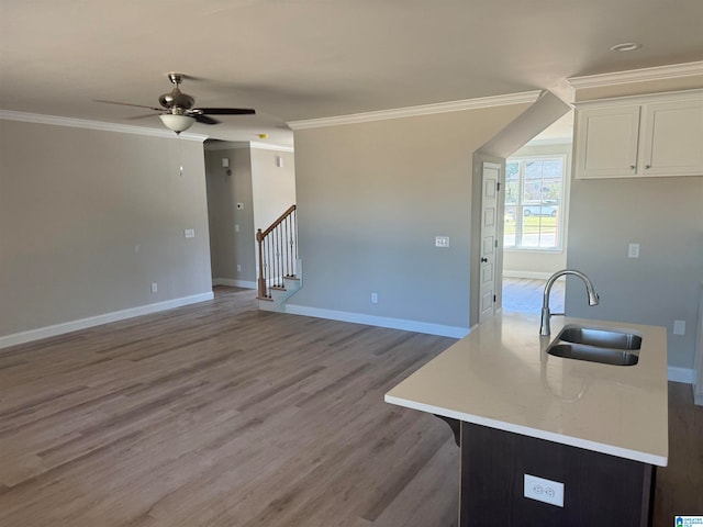 living room featuring stairs, crown molding, baseboards, and light wood-type flooring