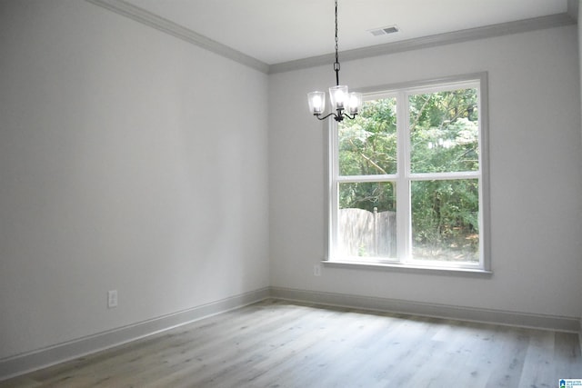 unfurnished room featuring visible vents, a notable chandelier, ornamental molding, wood finished floors, and baseboards