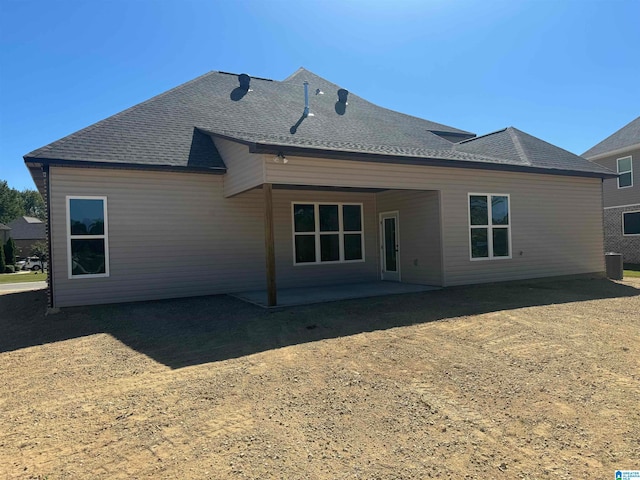 back of property with central AC and a patio