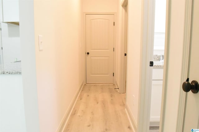 hallway with light wood-style floors and baseboards