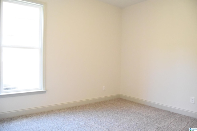 spare room featuring baseboards and carpet floors