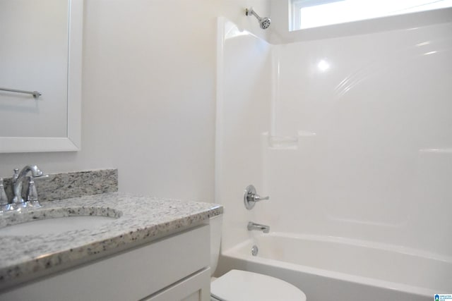 bathroom featuring toilet, vanity, and shower / bathtub combination