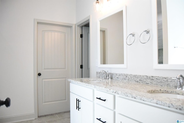 full bath featuring double vanity, tile patterned floors, and a sink