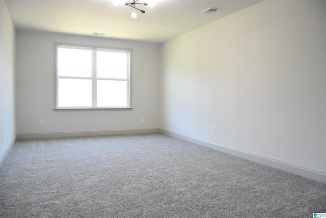 unfurnished room with visible vents, baseboards, and carpet