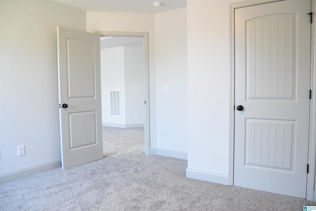 unfurnished bedroom with visible vents, baseboards, and carpet