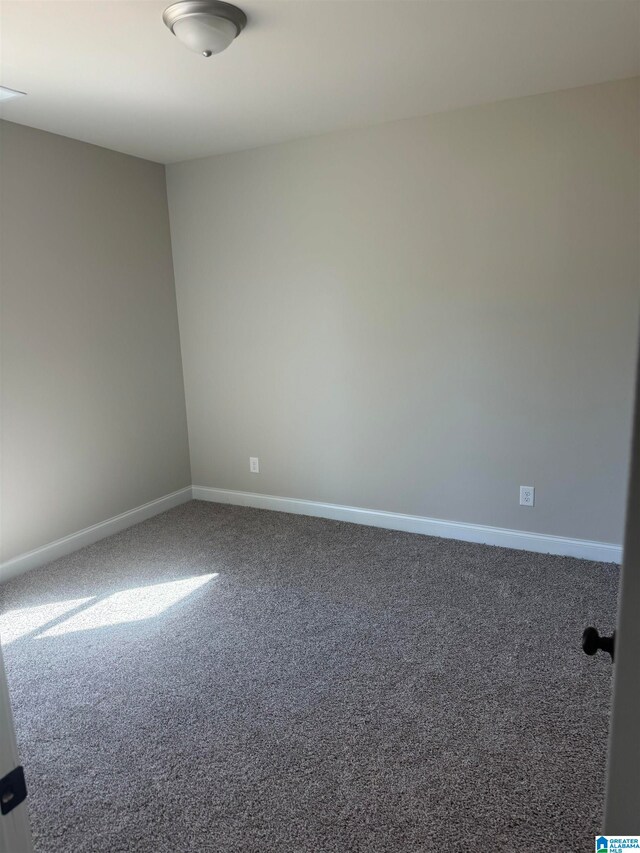 spare room with baseboards and carpet