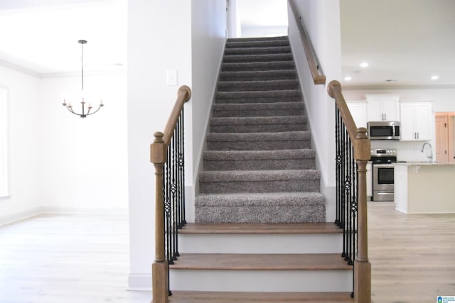 staircase featuring a notable chandelier, recessed lighting, and wood finished floors