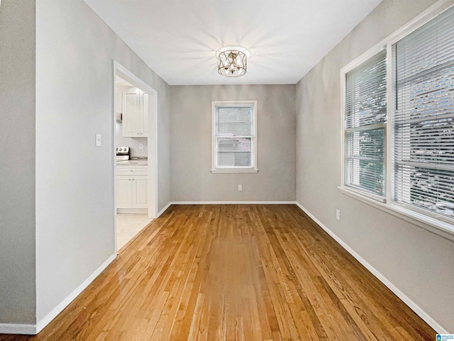 2400 2nd Ave N, Irondale, AL 35210 - unfurnished dining area featuring an inviting chandelier, baseboards, and light wood-style floors
