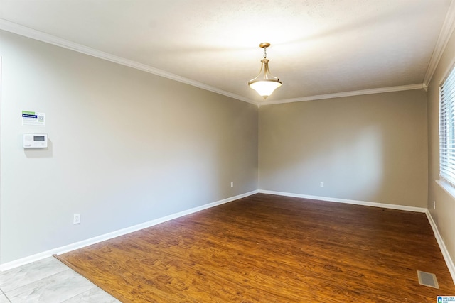 spare room with crown molding and hardwood / wood-style flooring