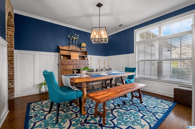 dining room featuring ornamental molding, a wealth of natural light, an inviting chandelier, and dark hardwood / wood-style flooring