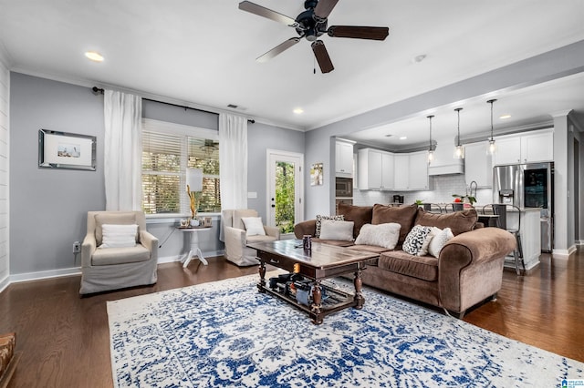 living room with crown molding, dark wood-type flooring, and ceiling fan