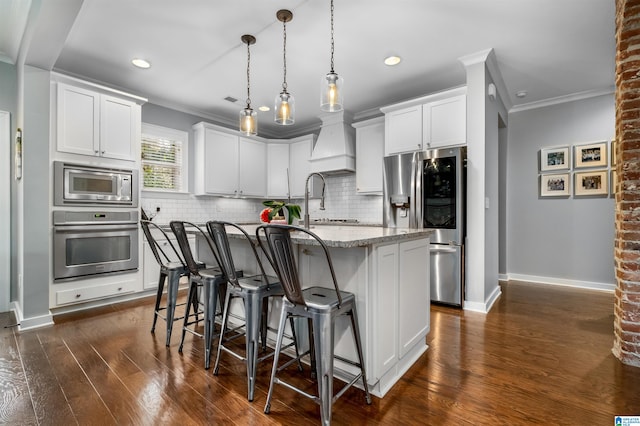 kitchen with dark hardwood / wood-style flooring, white cabinets, stainless steel appliances, and an island with sink