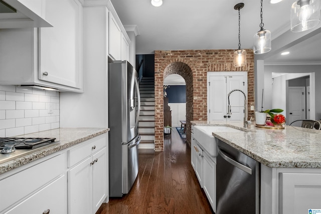 kitchen featuring stainless steel appliances, a center island with sink, sink, white cabinetry, and dark hardwood / wood-style flooring