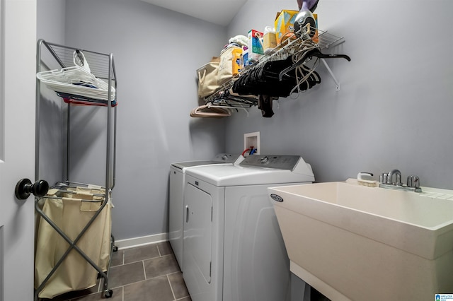 laundry room featuring sink, separate washer and dryer, and dark tile patterned flooring