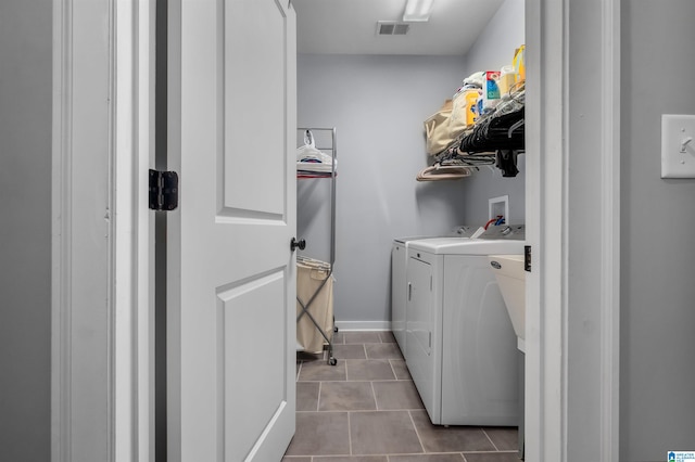 laundry area with washer and dryer and light tile patterned floors