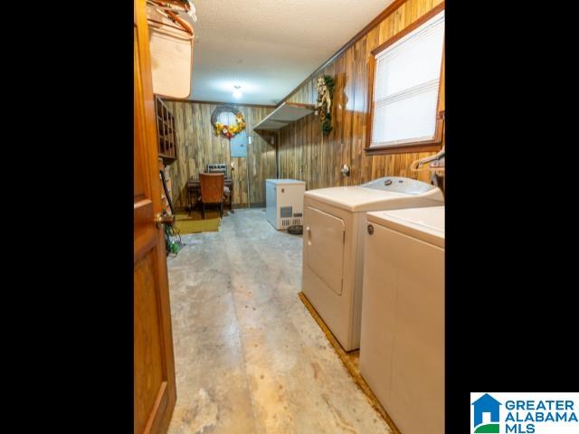 laundry area with independent washer and dryer and wooden walls