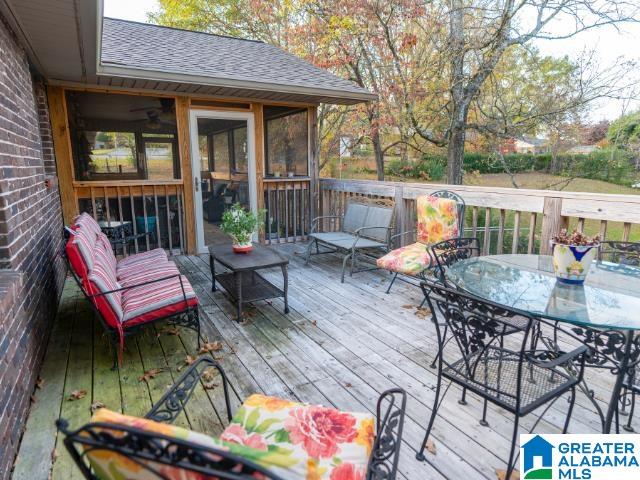 wooden deck featuring ceiling fan and a sunroom