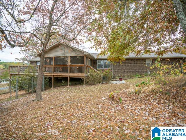 rear view of property with a deck and a sunroom