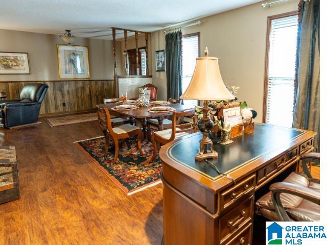 dining area with dark wood-type flooring and wood walls