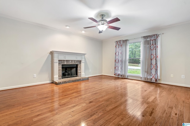 unfurnished living room with light hardwood / wood-style flooring, a fireplace, ceiling fan, and crown molding