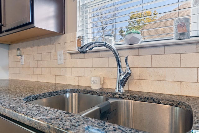 room details featuring dark stone countertops, tasteful backsplash, and sink