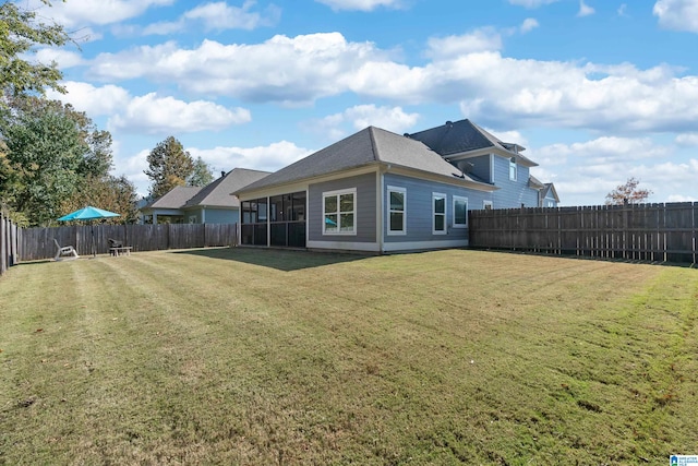 rear view of house with a yard and a sunroom