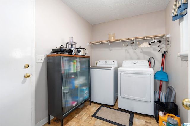 washroom featuring washer and clothes dryer and a textured ceiling