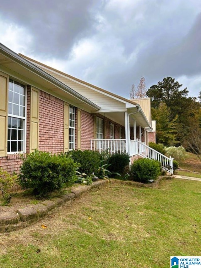 view of property exterior featuring a lawn and a porch