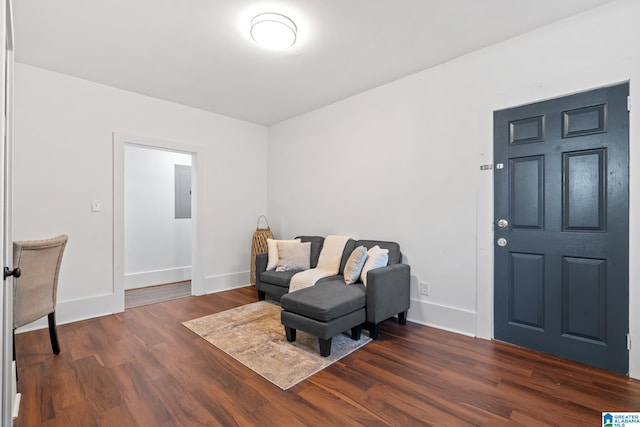 living area with dark wood-type flooring and electric panel