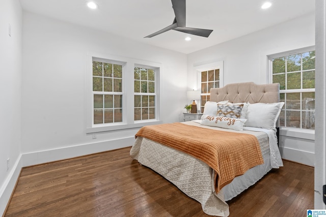 bedroom with ceiling fan, multiple windows, and dark hardwood / wood-style floors