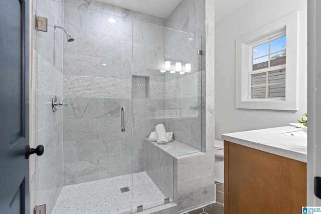 bathroom with vanity, toilet, tile patterned floors, and walk in shower