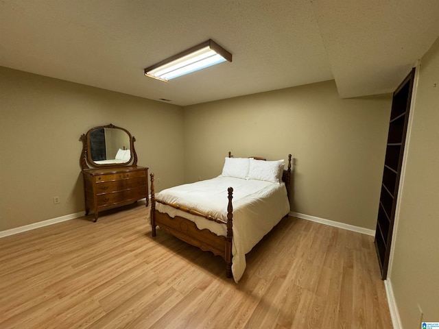 bedroom featuring light hardwood / wood-style flooring and a textured ceiling