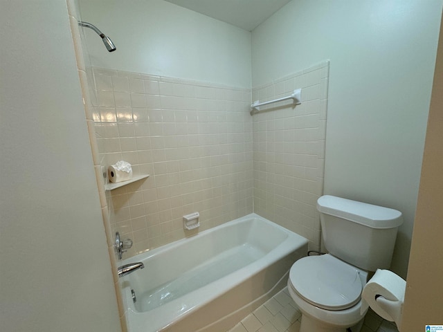 bathroom with tile patterned floors, tiled shower / bath combo, and toilet