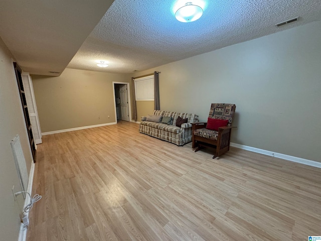 sitting room with a textured ceiling and light wood-type flooring