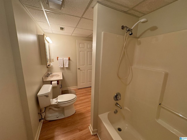 full bathroom featuring hardwood / wood-style flooring, toilet, bathtub / shower combination, a drop ceiling, and vanity