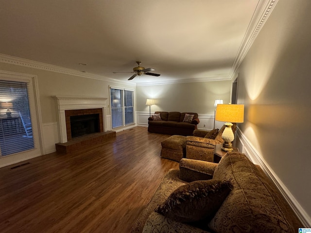 living room featuring ornamental molding, a brick fireplace, dark hardwood / wood-style floors, and ceiling fan