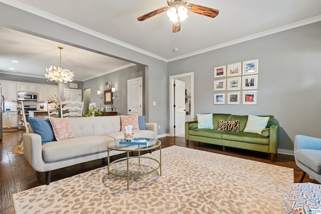 living room featuring dark wood-type flooring, ceiling fan with notable chandelier, and crown molding