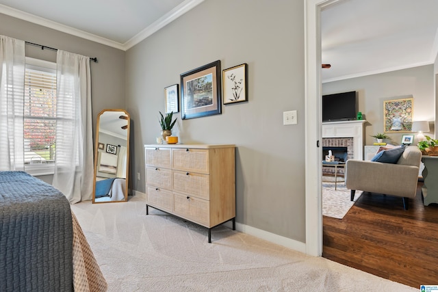 bedroom featuring a brick fireplace, light hardwood / wood-style floors, and crown molding