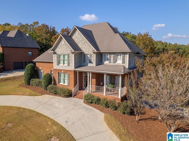 view of front of house with a porch, a front yard, and a garage