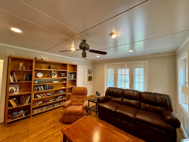 living room with hardwood / wood-style floors, ceiling fan, and crown molding