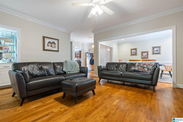 living room featuring crown molding, light wood-type flooring, and ceiling fan