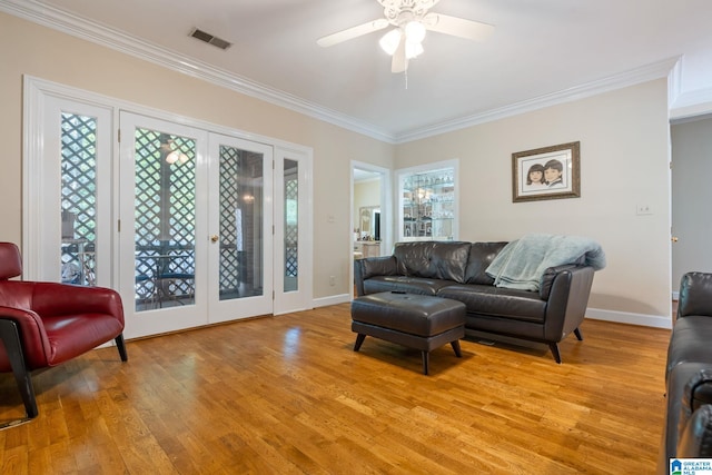 living room featuring light hardwood / wood-style flooring, ceiling fan, and crown molding