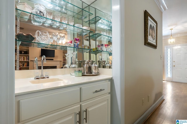 bathroom with vanity, ornamental molding, and wood-type flooring