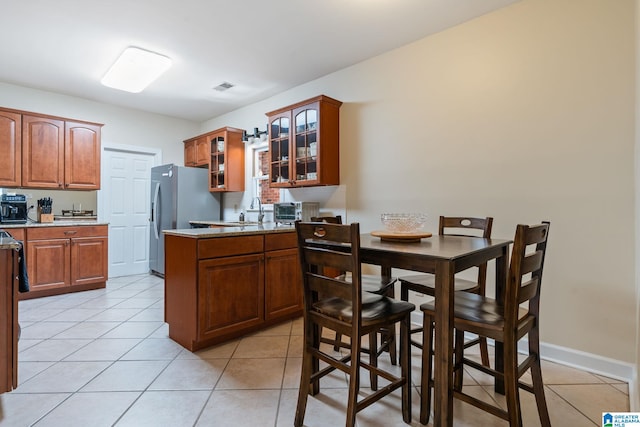 206 Morningside Cir Unit 206, Mountain Brook, AL 35213 - kitchen featuring visible vents, light tile patterned floors, stainless steel fridge with ice dispenser, a peninsula, and glass insert cabinets