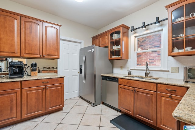 kitchen featuring stainless steel appliances, tasteful backsplash, sink, and light tile patterned flooring