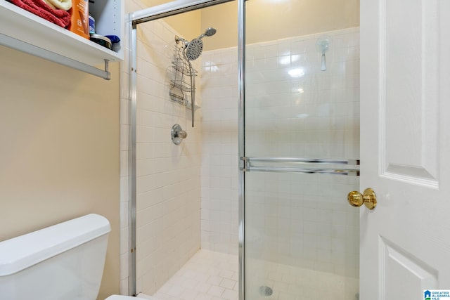 bathroom with a shower with shower door and toilet