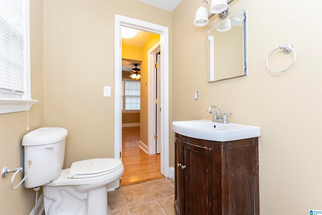 bathroom featuring vanity, toilet, tile patterned floors, and ceiling fan