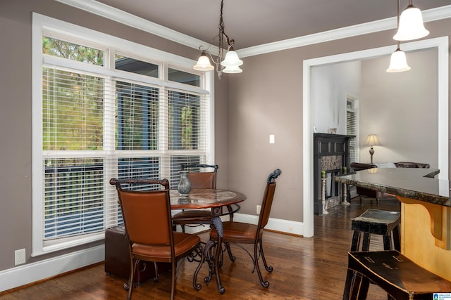 dining space with crown molding, dark hardwood / wood-style floors, and an inviting chandelier