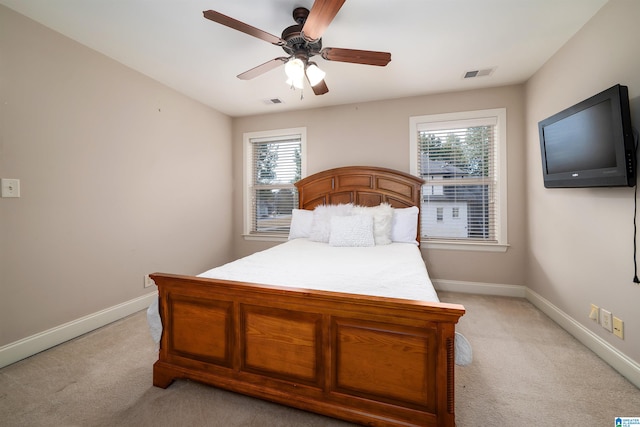 carpeted bedroom featuring multiple windows and ceiling fan