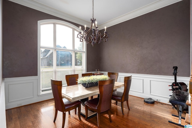 dining room featuring crown molding, hardwood / wood-style flooring, and a chandelier